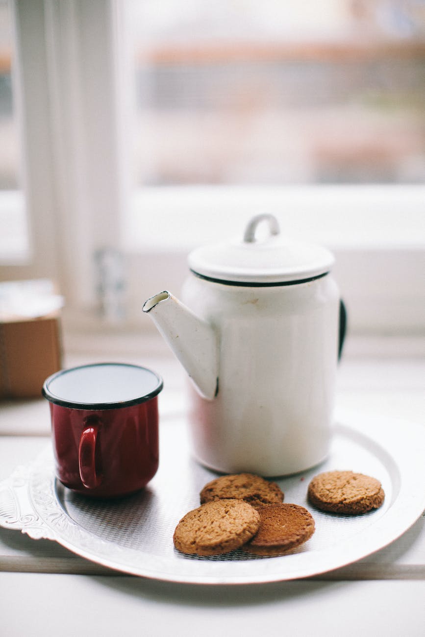 white teapot red mug and cookies